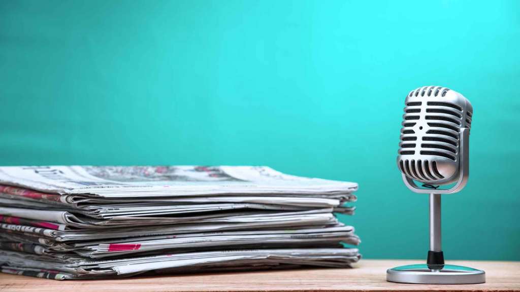 Retro microphone with newspaper on wooden table