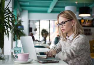 Busy female student preparing for exam in cafe