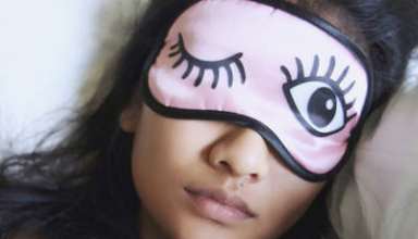 High Angle View Of Woman Wearing Eye Mask While Sleeping In Bed
