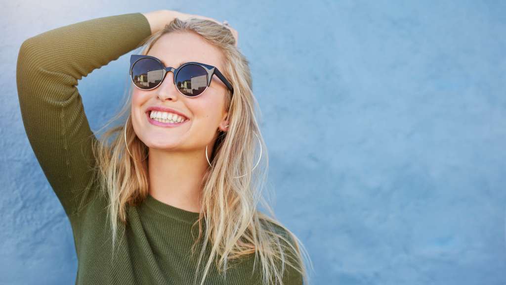 Close up shot of stylish young woman in sunglasses smiling Wallpaper