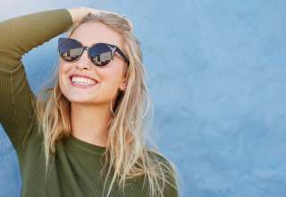 Close up shot of stylish young woman in sunglasses smiling Wallpaper