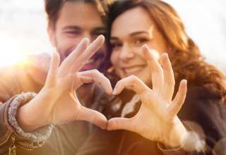 Close-up of couple making heart shape with hands Wallpaper