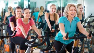 Positive females of different age training on exercise bikes Wallpaper