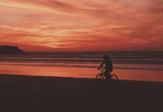 Bicyclist Sea Shore Sunset Wallpaper