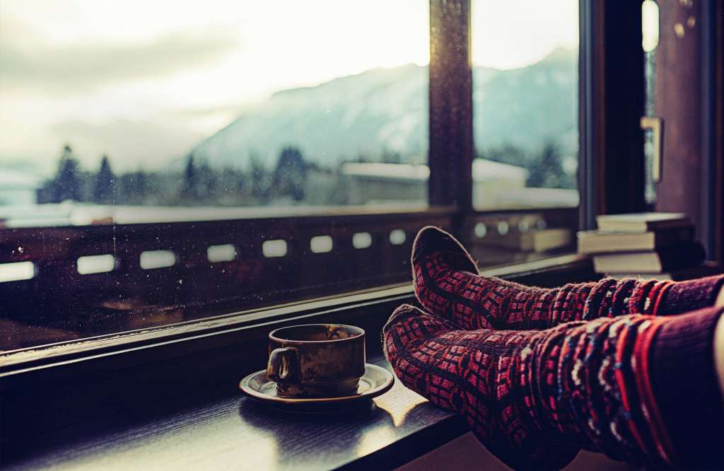 Feet in woollen socks by the Alps mountains view