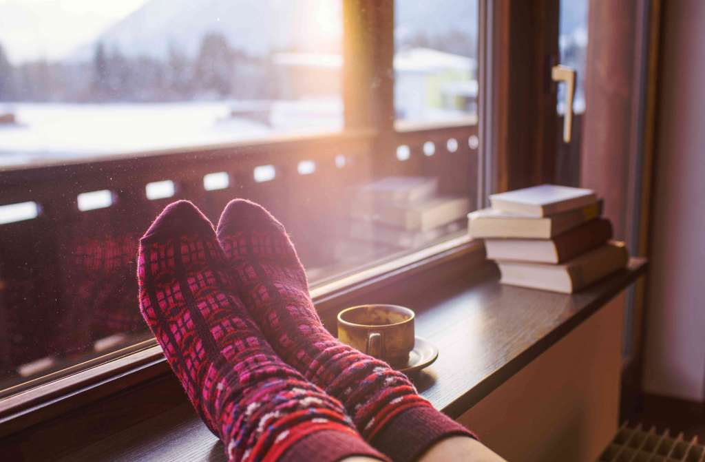 Feet in woollen socks by the Alps mountains view