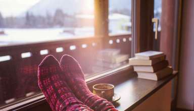 Feet in woollen socks by the Alps mountains view