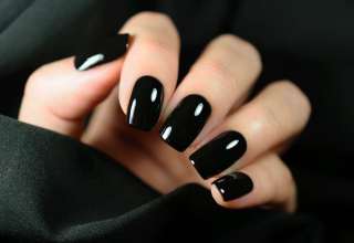 Manicure on female hands with black nail polish