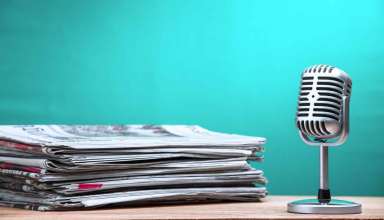 Retro microphone with newspaper on wooden table