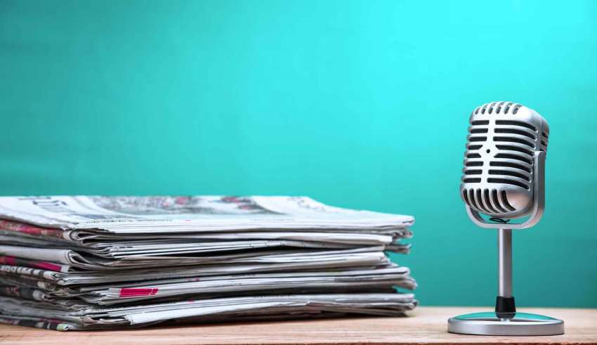 Retro microphone with newspaper on wooden table
