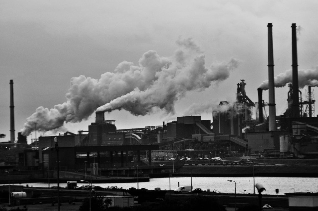 Grayscale Photography of Locomotive Train Beside Factory Wallpaper