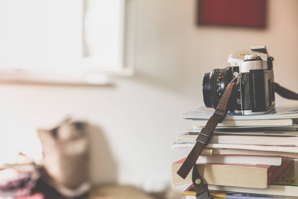 Black Bridge Camera on Top of Piled Books Wallpaper