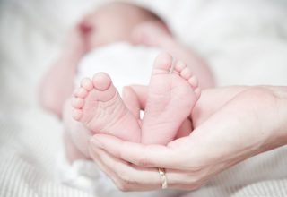 Close-up of Hands Holding Baby Feet Wallpaper