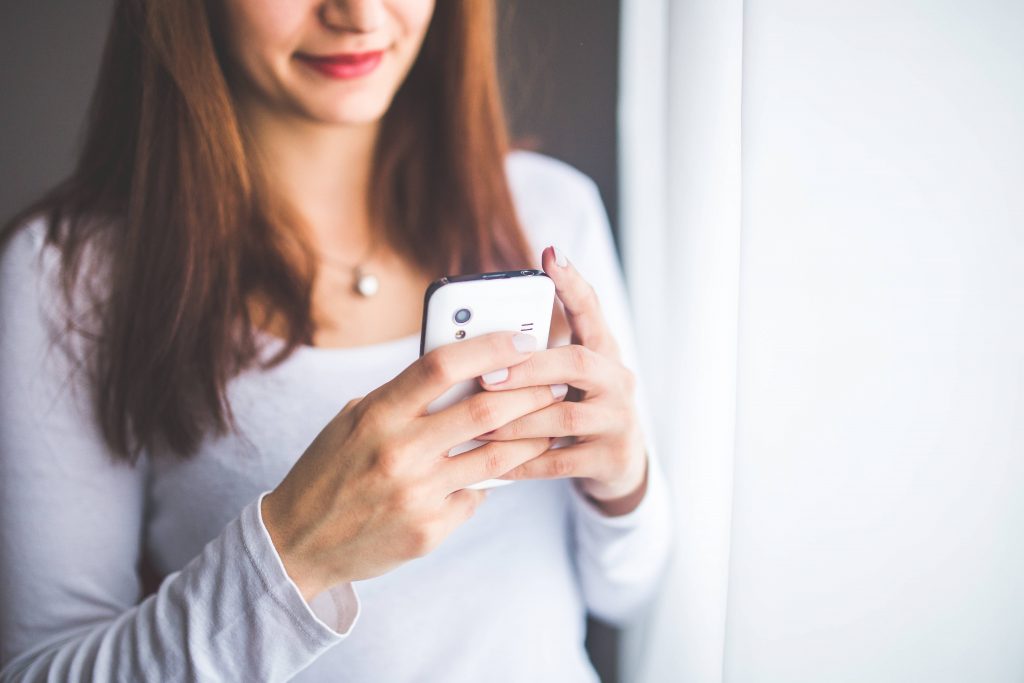 Close-up Portrait of Young Woman Typing a Message on Mobile