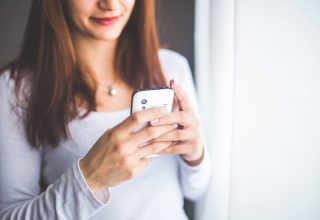 Close-up Portrait of Young Woman Typing a Message on Mobile