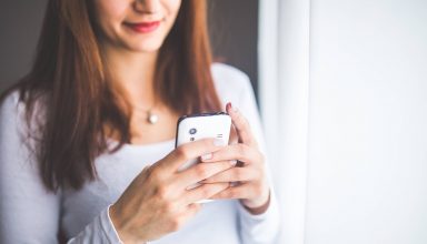 Close-up Portrait of Young Woman Typing a Message on Mobile