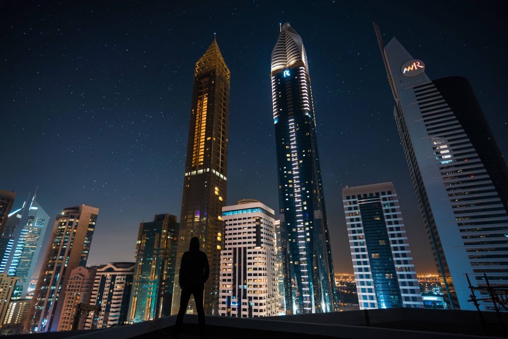 Man Standing Front of Tall Buildings Wallpaper