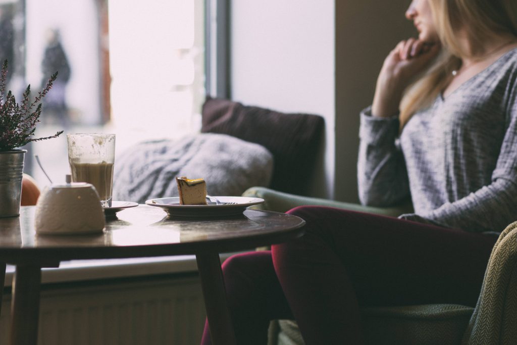 Photography of Woman Near Round Table During Daytime Wallpaper