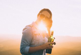 Woman Blue Jacket Holding Wine Bottle Wallpaper