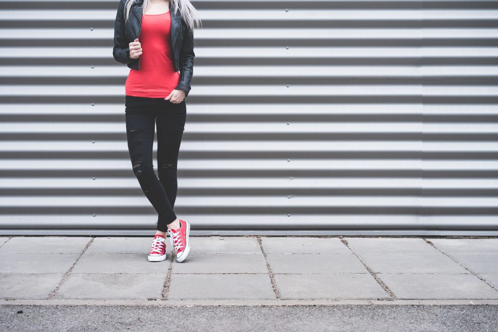 Young Woman Standing in Front of Metallic Wall