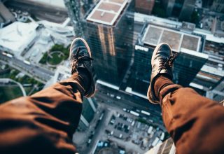 Man Sitting on Top of a Rooftop Wallpaper