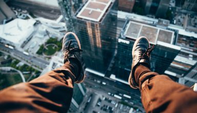 Man Sitting on Top of a Rooftop Wallpaper