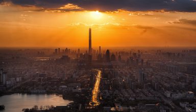 Tall Buildings Tower Sun in Clouds Lake Cityscape Wallpaper